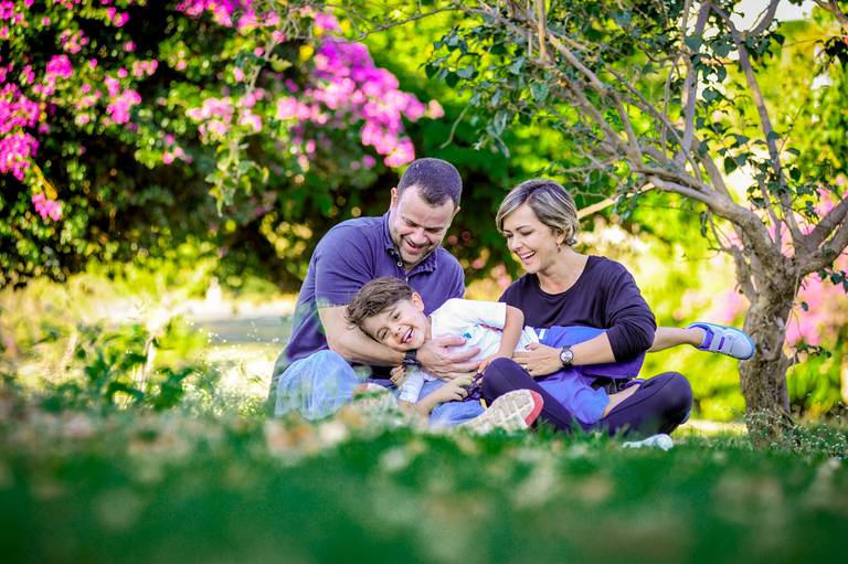 familia sentada na grama sorrindo