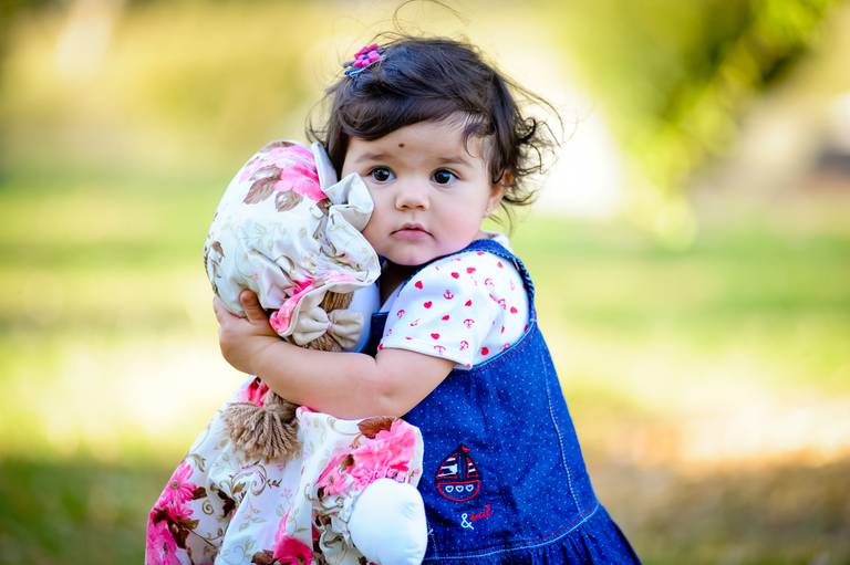 menina abracando boneca