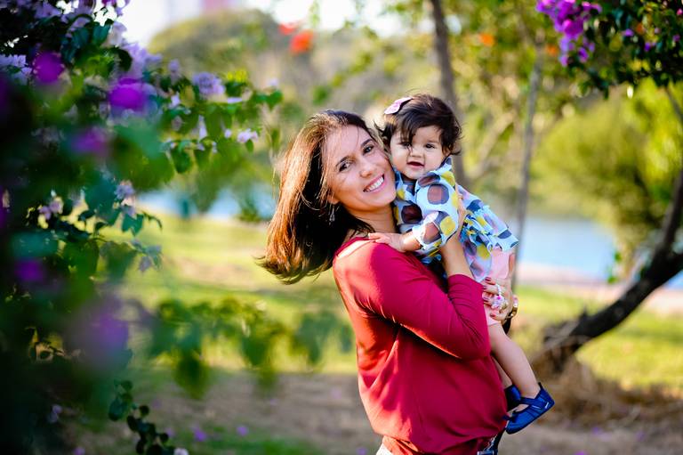 mae segurando menina em jardim
