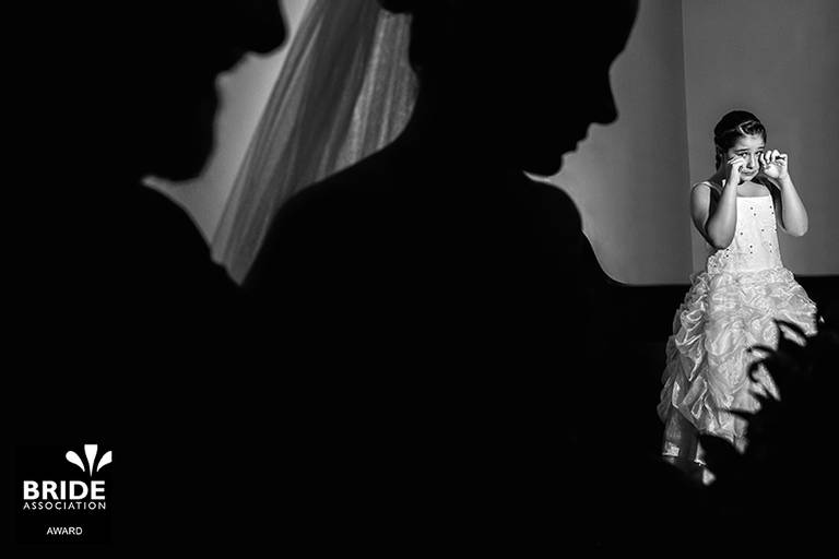 uma das fotos mais premiadas do mundo aconteceu em um casamento onde a daminha estava chorando vendo sua irma a noiva entrar com o seu pai indo em direção ao altar 