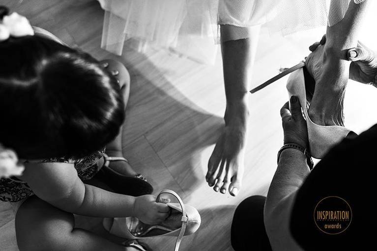 foto da daminha ajudando a noiva a por o sapato ganha premio entre as melhores fotos de casamento do mundo segundo o Inspiration fotografos e vira inspiração para varias noivas