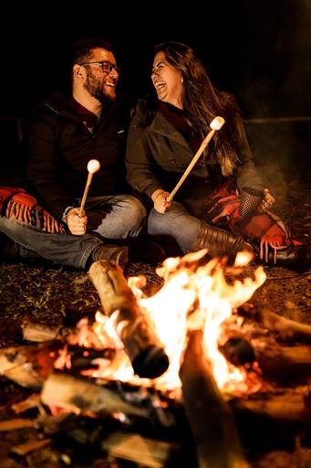 Namorados no acampamento ensaio romântico namorar no frio em frente a fogueira 