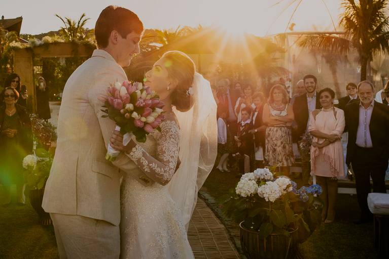 fotografia dos noivos na cerimonia do casamento ao ar livre na praia com por do sol, fotografia documental de casamento por daniel okuyama o melhor fotógrafo do Brasil
