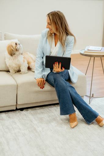 Ensaio Corporativo, profissinal. Mulher sentada no sofa do escritório com tablet e cachorro