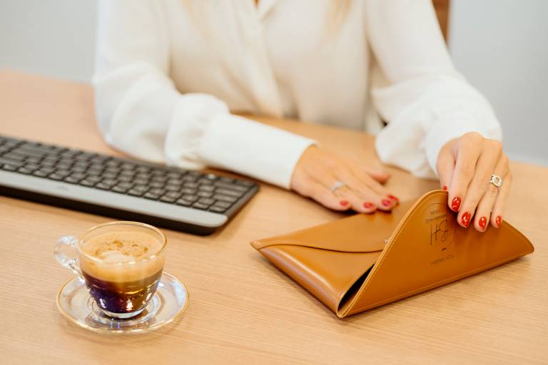 Ensaio Corporativo, profissinal. um café e teclado mãos mexendo em um envelope de couro