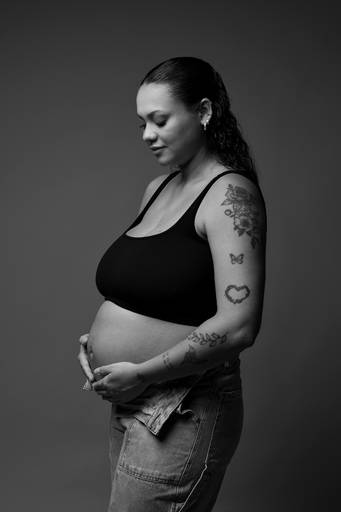Ensaio gestante em estúdio, barriga a mostra, gestante abraça a barriga