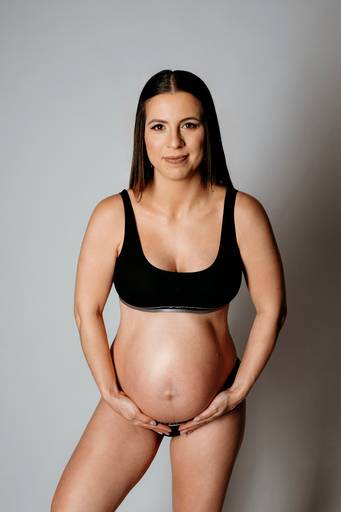Ensaio gestante em estúdio, barriga está aparecendo, gestante está usando conjunto da Calvin Klein
