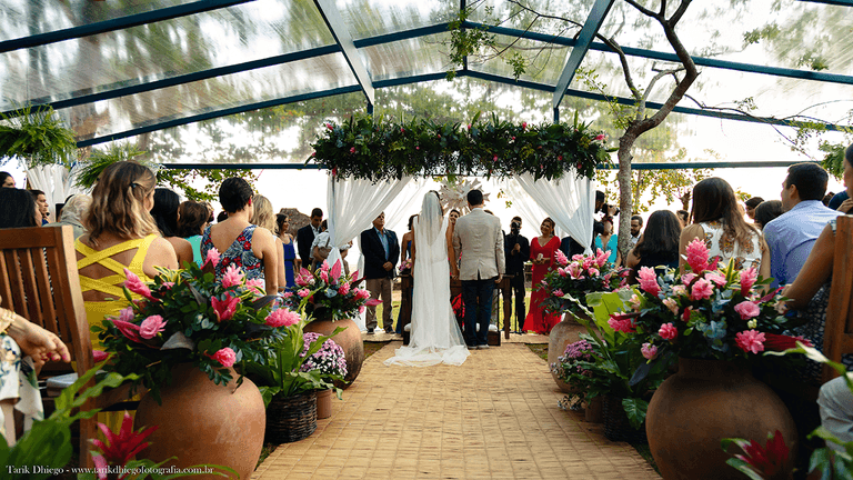 fotografia dos noivos de costas, mostrando o vestido de noiva, o traje do noivo, a decoração de casamento pé na areia, na reserva tambá, na praia de toque toque pequeno em são sebastião, são paulo, destination wedding, casamento em punta cana