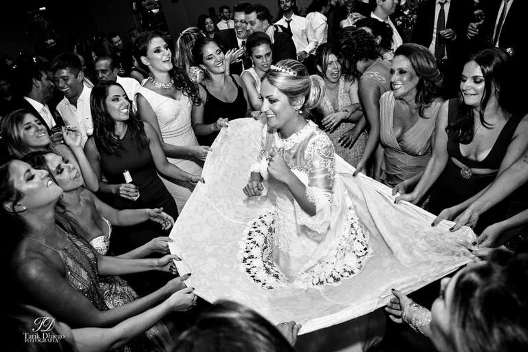 noiva dançando com as madrinhas, foto em preto e branca, noiva na pista, madrinhas segurando o vestido da noiva e dançando