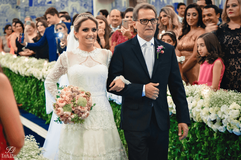 entrada da noiva com vestido branco e buquê de rosas ao lado do seu pai com terno preto na igreja nossa senhora do brasil