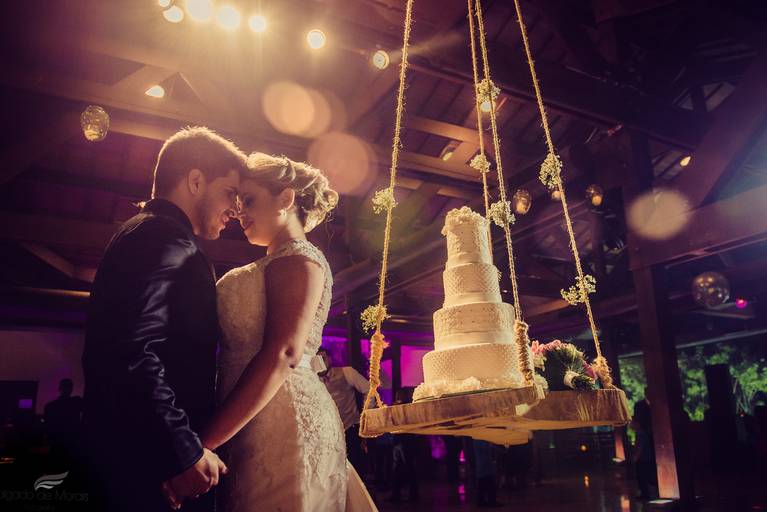 foto de casal de noivos na mesa do bolo com uma luz incrível