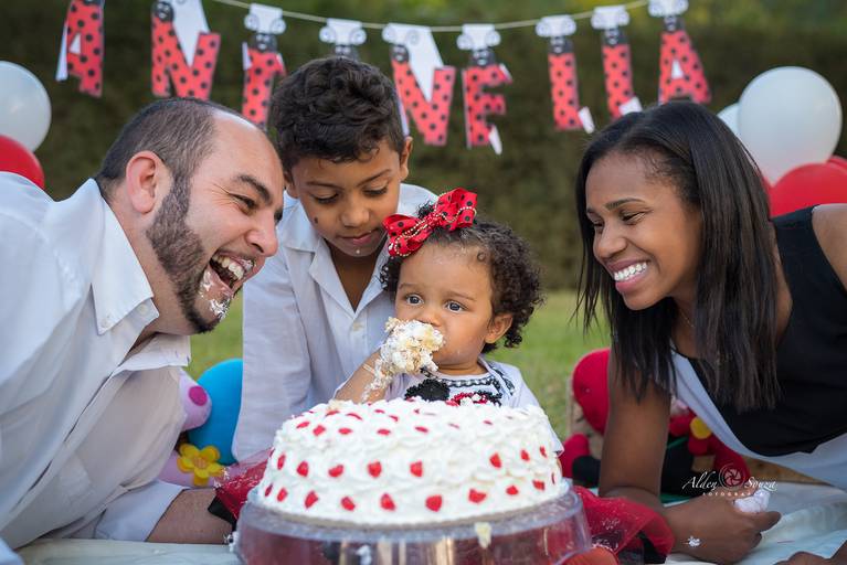 criança comendo bolo com familia
