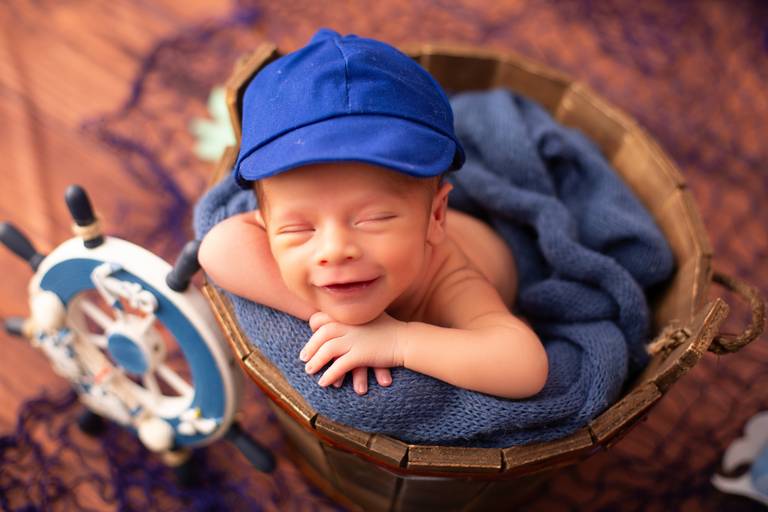 Bebê sorrindo durante ensaio de acompanhamento mensal em estúdio, com cenário lúdico e colorido. Fotografia infantil realizada pela Luana Nicolete Fotógrafa em São José do Rio Preto.