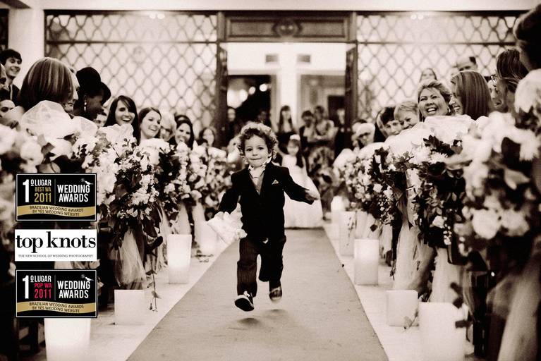 Foto premiada no top knots e no wedding awards, Pagem entrando na igreja correndo segurando as alianças.