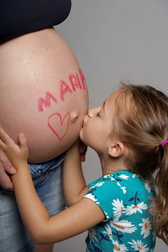 Ensaio gestante em estúdio  fotografado pelo melhor fotógrafo de Curitiba e Campo Largo, Michel Druziki. Filha dando beijo na barriga da mãe grávida