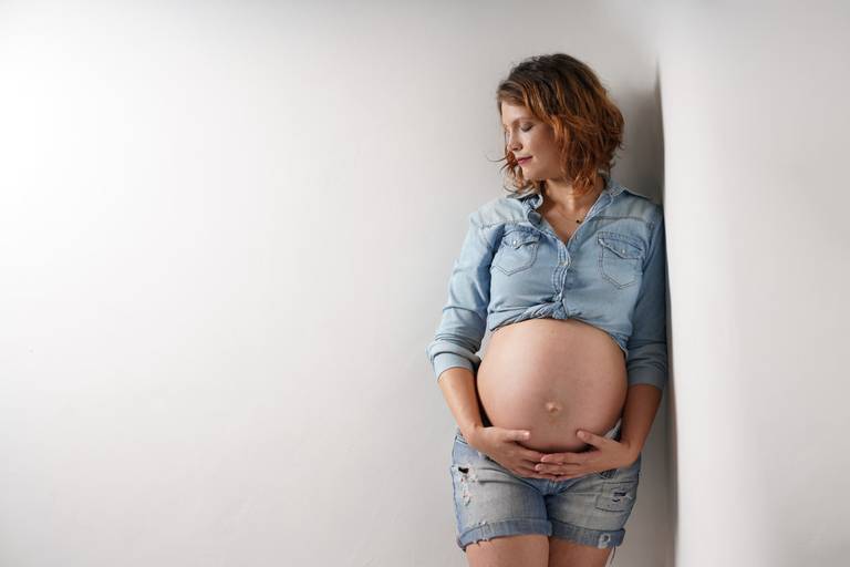 Ensaio gestante em estúdio  fotografado pelo melhor fotógrafo de Curitiba e Campo Largo, Michel Druziki. Gestante com shorts e camisa jeans