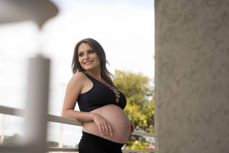 ensaio gestante de top preto sorrindo