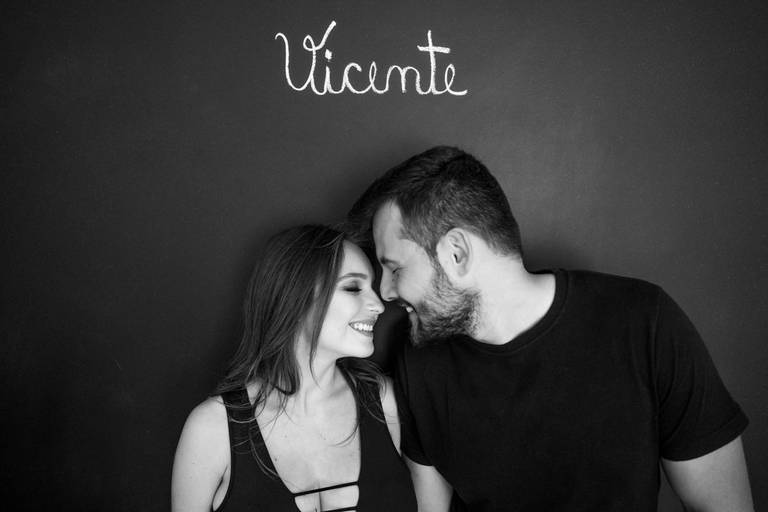 ensaio gestante com marido em frente a parede escrito o nome do bebê