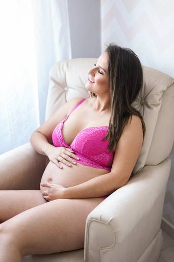Ensaio gestante life style fotografado pelo melhor fotógrafo de ensaios de campo largo e Curitiba, Michel Druziki. Gestante sentada na poltrona sorrindo