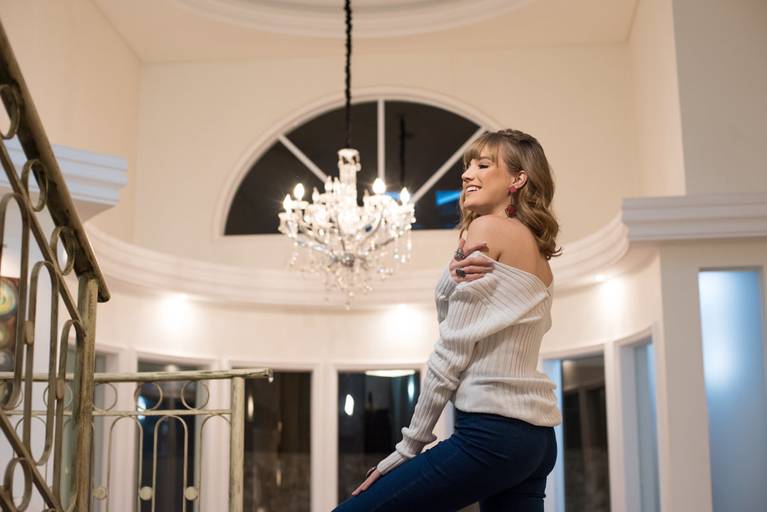 Editorial fotografado pelo melhor fotógrafo de campo largo e Curitiba, Michel Druziki. Modelo na escada com blusa de lã branca 