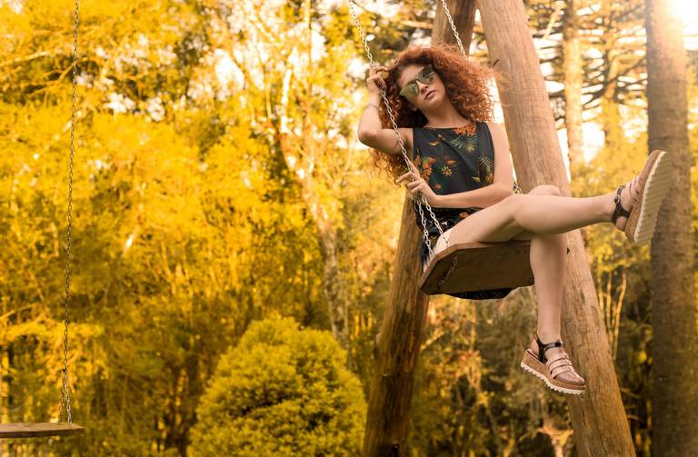 Michel druziki melhor fotografo de curitiba e campo largo ensaio externo dia ensolarado mulher cabelo ruivo cacheado na balança 