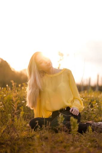 Ensaio fotografado pelo melhor fotógrafo de campo largo e Curitiba, Michel Druziki. Modelo de óculos sentada na grama no por do sol