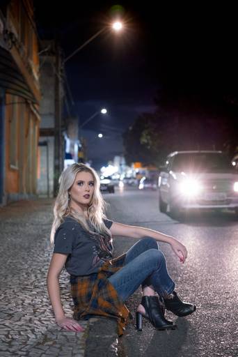 Editorial fotografado pelo melhor fotógrafo de campo largo e Curitiba, Michel Druziki. Modelo com calça jeans, camisa xadrez sentada na calçada 