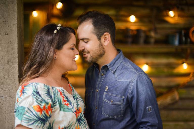 Ensaio de gestante fotografado pelo melhor fotógrafo de ensaios de campo largo e Curitiba. Casal de olhos fechados em frente à casa iluminada