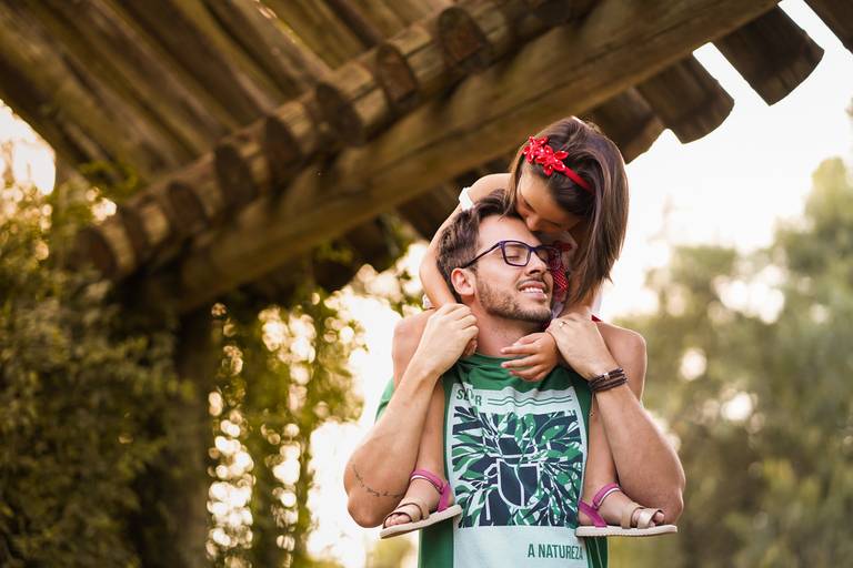 Ensaio da família Albach fotografado por um dos melhores fotógrafos do Brasil, Michel Druziki. Filha nos ombros do pai dando um beijo na testa