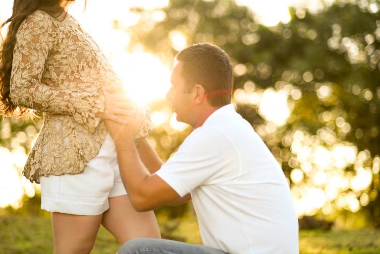 Ensaio gestante marido beijando a barriga da esposa no campo, pelo melhor fotógrafo de Curitiba e Campo Largo, Michel Druziki.