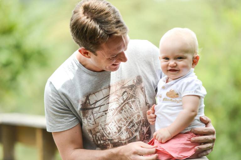 Família feliz, pai, mãe e filha fotografados pelo melhor fotógrafo de Curitiba e Campo Largo, Michel Druziki. Pai fazendo cócegas na filha