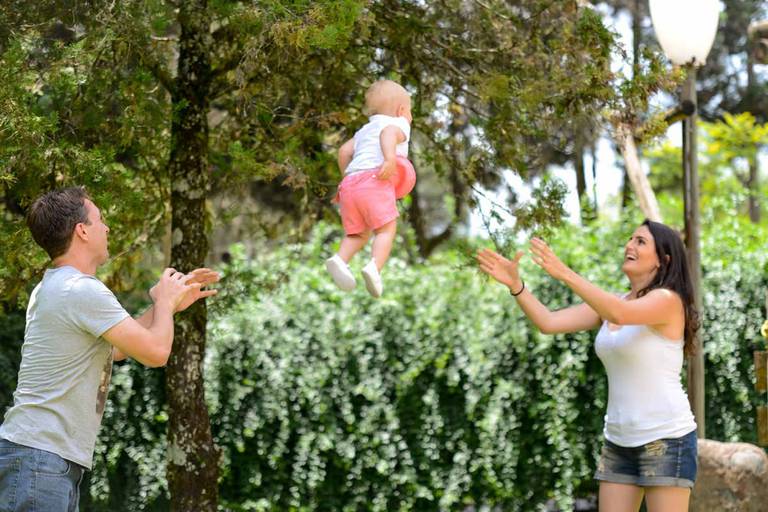 Família feliz, pai, mãe e filha fotografados pelo melhor fotógrafo de Curitiba e Campo Largo, Michel Druziki. Pai jogando filha para a mãe