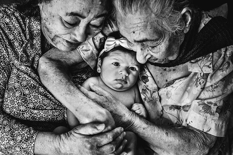 Fotografia documental de familia com foco emotivo e conexão de amor detalhes de familia maes pais bebe avós com relação de amor e arte pela fotografa pramiada nayara andrade fotografia de santos litoral de sao paulo
