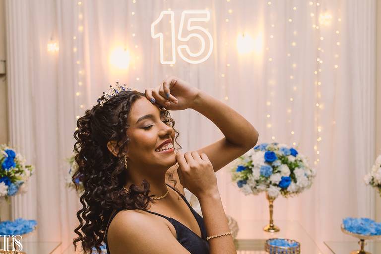 festa de 15 anos debutante sorrindo com mesa do bolo de fundo -fotografa em sbc sp
