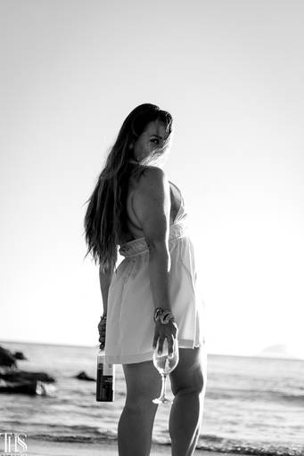 Foto preto e branco de mulher com vinho em praia - fotografa em sbc