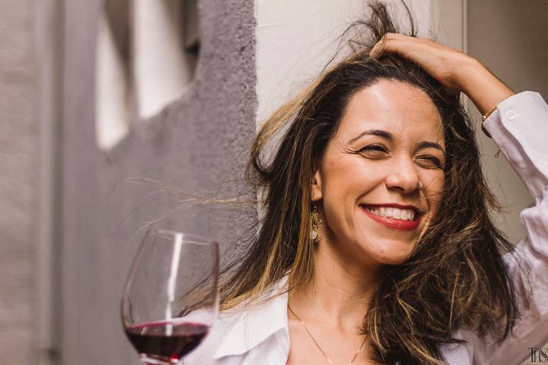 Mulher tomando vinho e sorrindo em ensaio intimista feminino na cidade de São Bernardo do Campo - SP - Fotógrafa Thaís Silvério