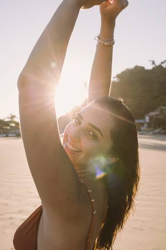 ensaio feminino mulher na praia com raios de sol em volta dela -fotografa em sbc sp