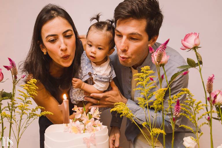 bebê e pais assoprando a vela - fotografa em sp sbc