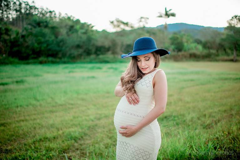 gravida roupa em vestido branco com chapeu azul fotografado por chandra cardoso fotografias