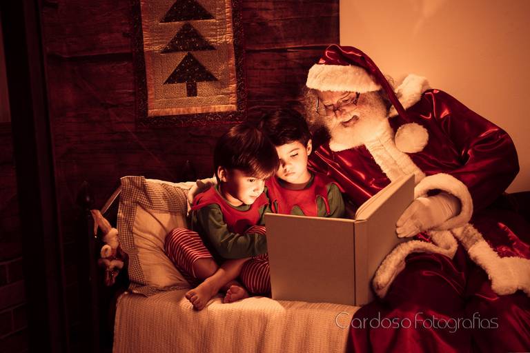 papai noel le para meninos durante ensaio de natal