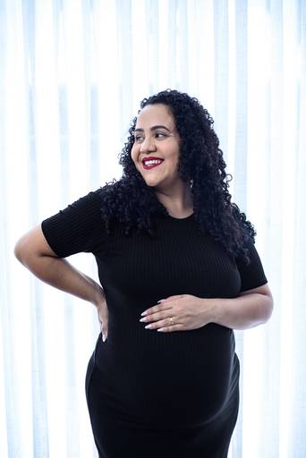 Gestante com vestes pretas no estúdio.