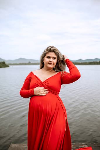 Gestante com vestido vermelho no lago 