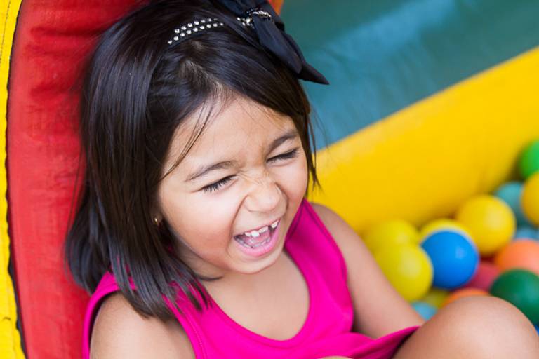 Garotinha-simpática-sorrindo-dentro-de-piscina-de-bolinhas-foto-tirada-por-thais-mazzoco
