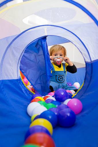 Menino-loiro-de-chupeta-dentro-de-piscina-de-bolinhas-coloridas