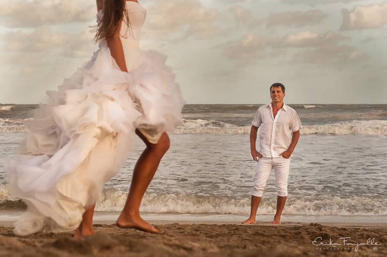 Novia con vestido blanco en la playa junto al mar. Pinamar, book de novios.