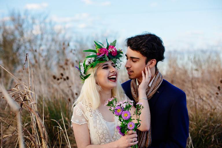 Novios en el campo al atardecer. Vestido de novia y ramo con corona de flores silvestres. Tocado de novia. Fotografía Erika Fayolle. Book de novios.