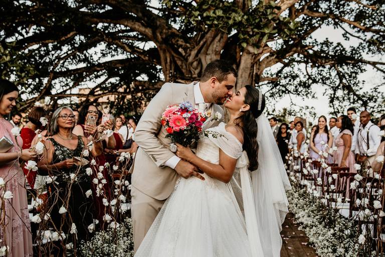 Ceremonia al atardecer en el mar. Brasil. Playa. Boda al atardecer. Beso de novios. Erika Fayolle