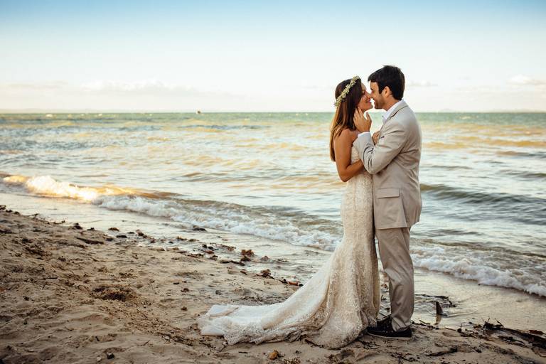 boda casamiento en la playa al atardecer. Pareja de novios en el mar