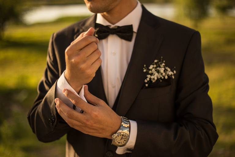 Novio vistiéndose en los preparativos de su casamiento.