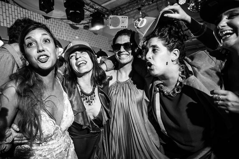 Casamiento divertido en Posta 36. Carnaval carioca con cotillón. Novia con su vestido bailando con amigas. Foto blanco y negro Erika Fayolle